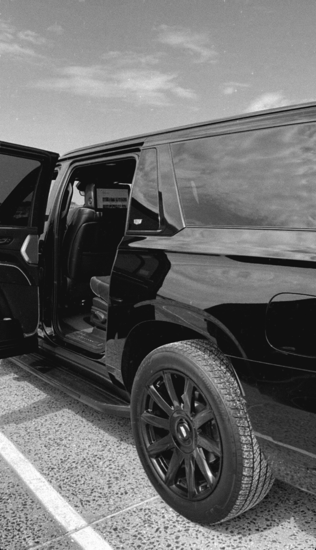 Black executive SUV under street light at night